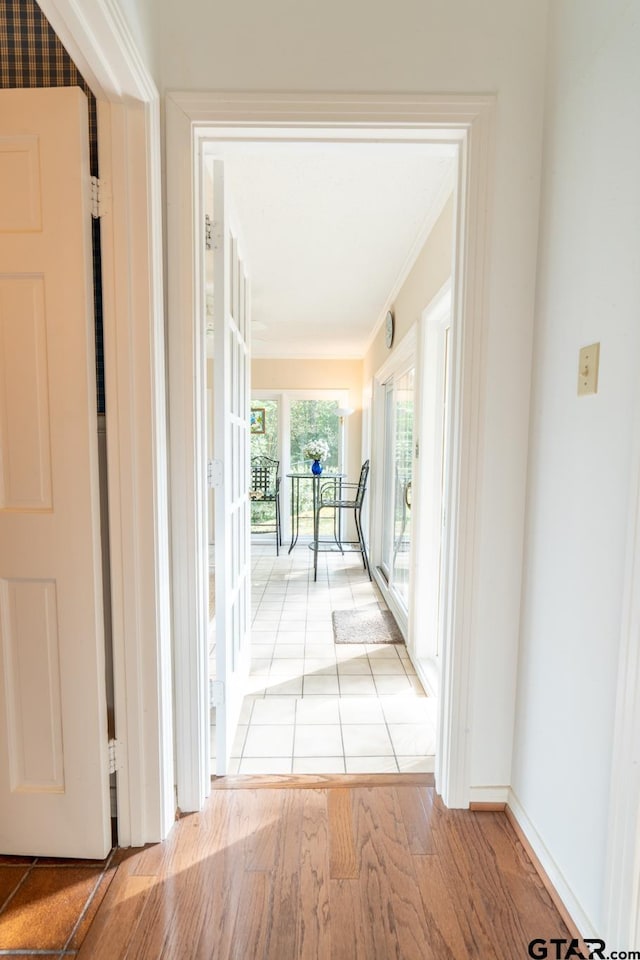 corridor featuring crown molding and light wood-type flooring