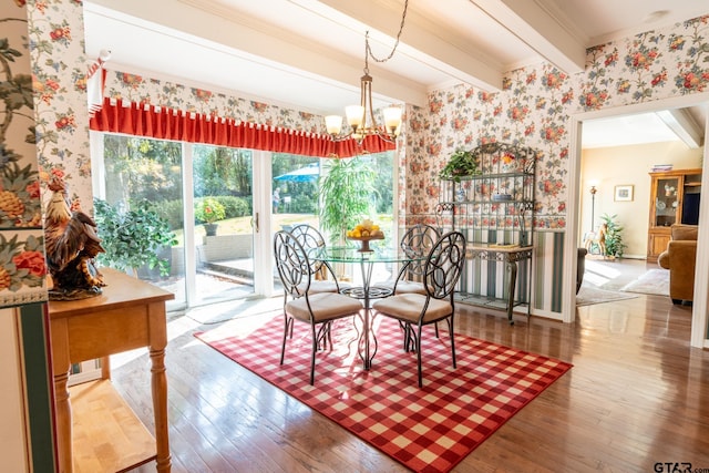 dining space with hardwood / wood-style flooring, crown molding, an inviting chandelier, and beam ceiling