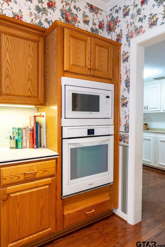 kitchen with dark wood-type flooring and white appliances