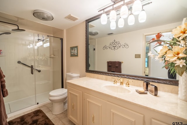 bathroom with vanity, tile patterned floors, toilet, and walk in shower