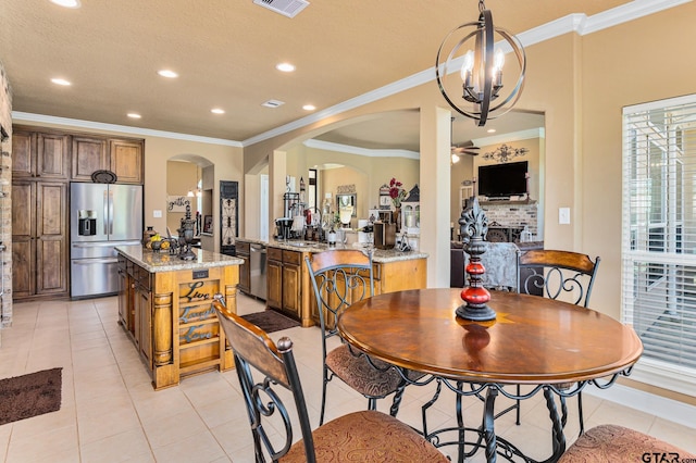 dining area featuring ornamental molding, a fireplace, light tile patterned floors, and sink