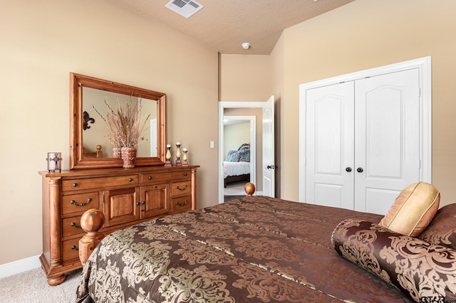 carpeted bedroom with a textured ceiling and a closet