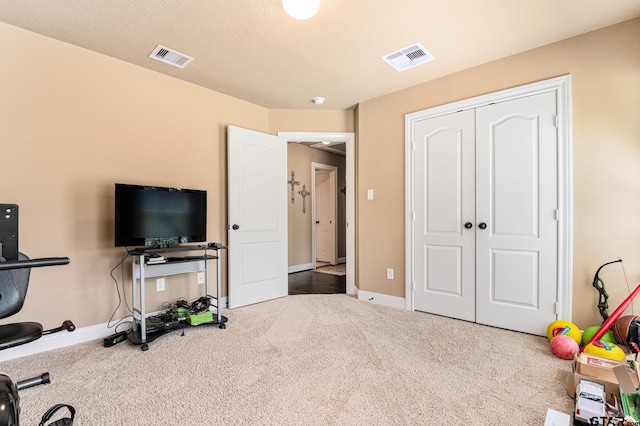 workout area featuring carpet and a textured ceiling