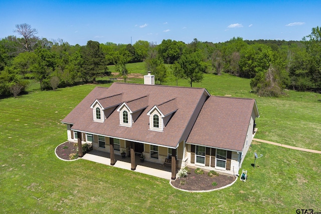 909 Crk 3045, Crockett, TX 75835 - view of front of home featuring a patio, a front lawn, a wooded view, and a chimney