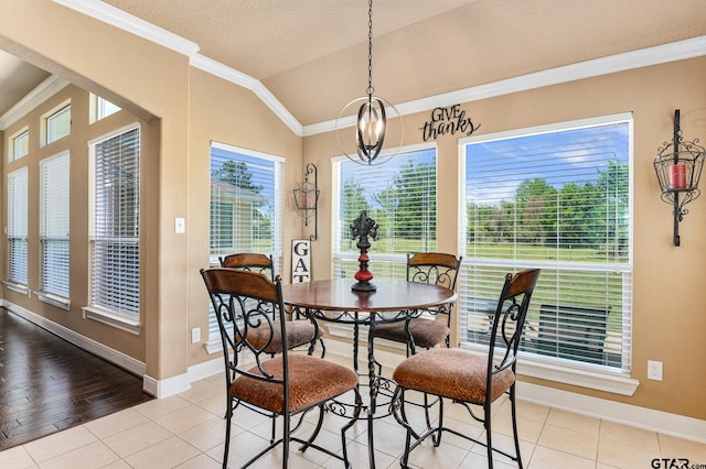 dining room with a chandelier, plenty of natural light, light hardwood / wood-style flooring, and lofted ceiling