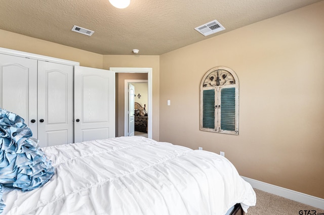 bedroom with carpet flooring, a textured ceiling, and a closet