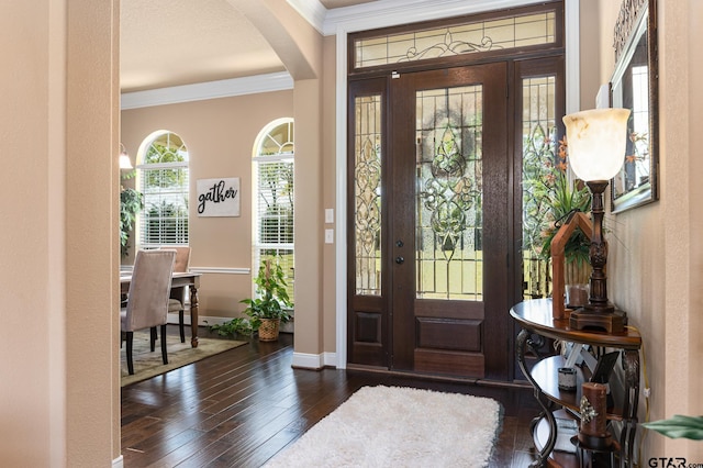 entryway with ornamental molding and dark hardwood / wood-style floors