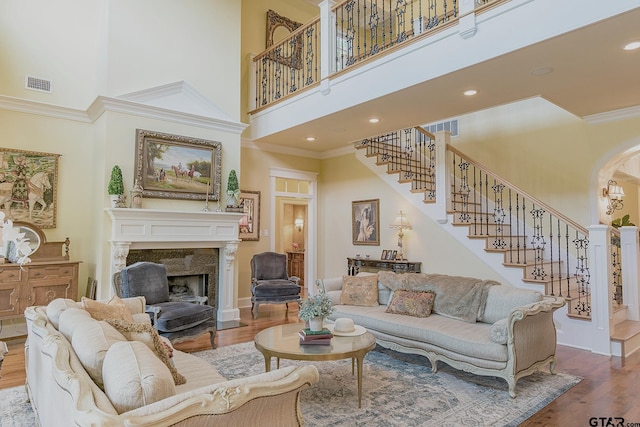 living room featuring a high ceiling, crown molding, and hardwood / wood-style floors