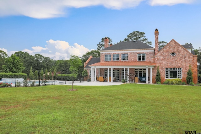 back of property featuring a lawn and a patio area