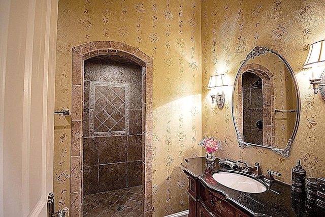 bathroom with vanity and a tile shower