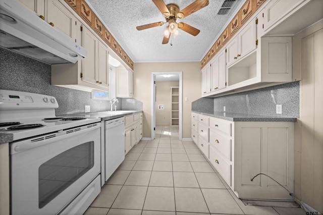 kitchen with white cabinets, a textured ceiling, white appliances, and light tile patterned floors