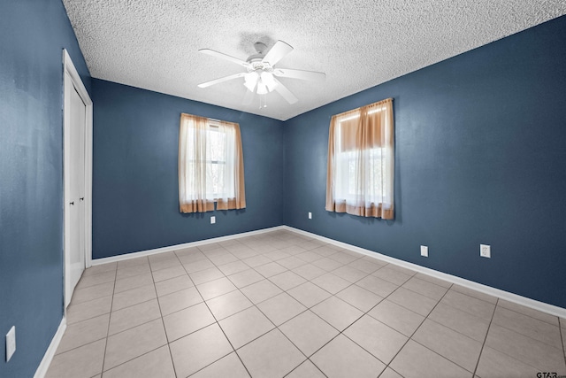 unfurnished bedroom featuring a textured ceiling, light tile patterned floors, and ceiling fan