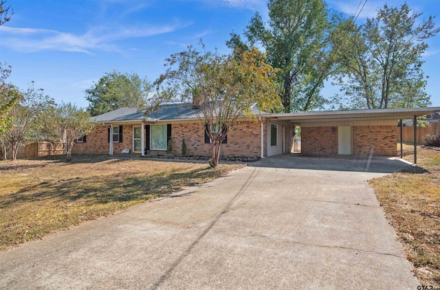 ranch-style home featuring a front lawn and a carport