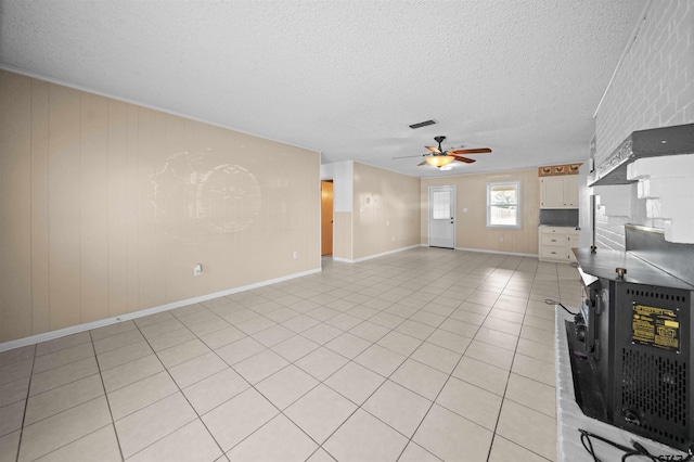 unfurnished living room featuring ceiling fan, a textured ceiling, and light tile patterned floors