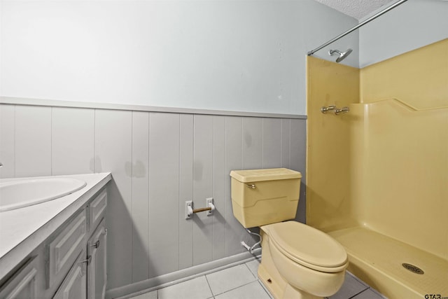 bathroom featuring tile patterned floors, walk in shower, vanity, a textured ceiling, and toilet