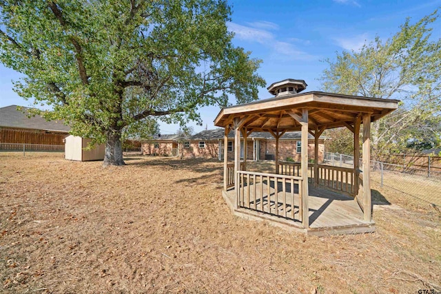 view of yard featuring a storage unit, a wooden deck, and a gazebo