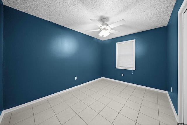 empty room with light tile patterned flooring, ceiling fan, and a textured ceiling