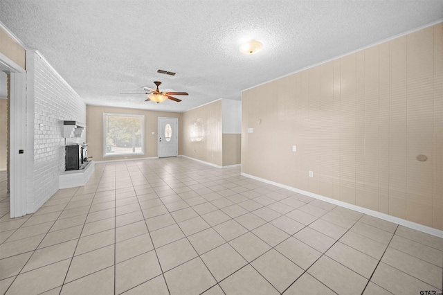 unfurnished living room with a textured ceiling, light tile patterned floors, ceiling fan, and a fireplace