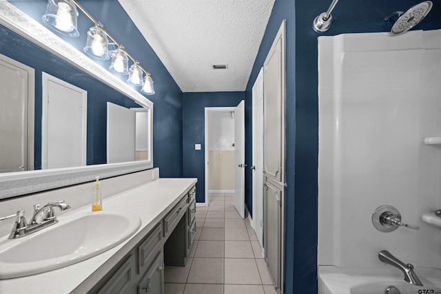 bathroom with tile patterned flooring, vanity, a textured ceiling, and shower / bathing tub combination