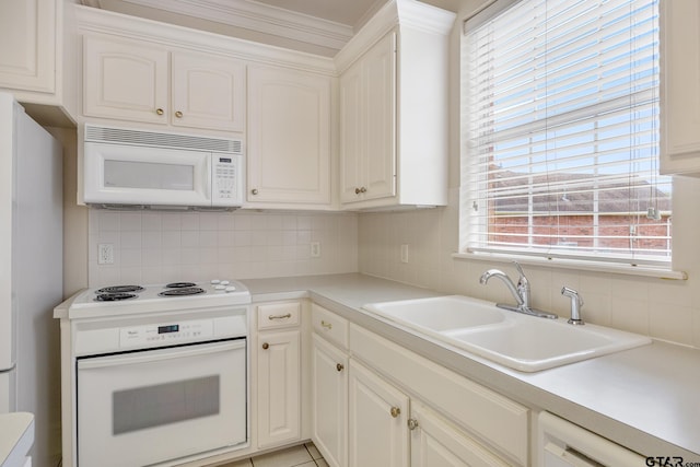 kitchen with white appliances, white cabinetry, sink, and decorative backsplash