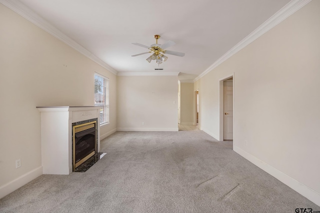 unfurnished living room featuring a premium fireplace, ceiling fan, light colored carpet, and ornamental molding