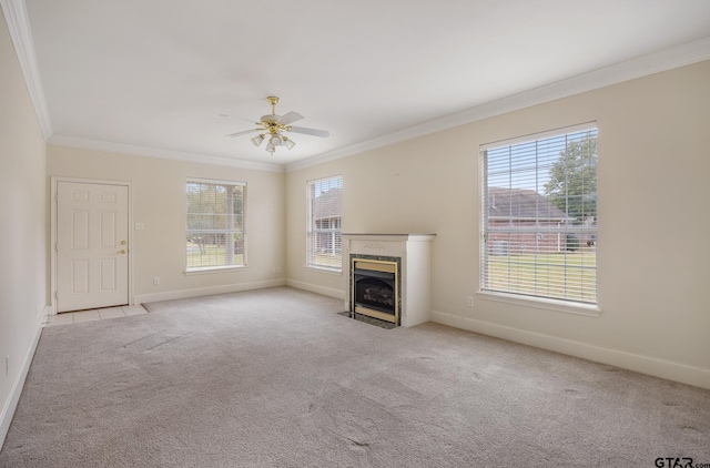 unfurnished living room featuring ornamental molding, light carpet, ceiling fan, and a high end fireplace