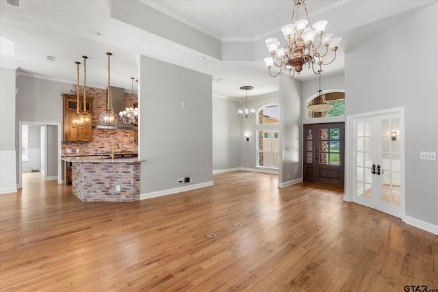 89 Eagle Cv, Mount Vernon, TX 75457 - entryway with a chandelier, ornamental molding, light wood finished floors, baseboards, and a towering ceiling