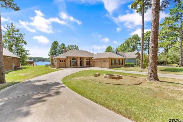 single story home featuring a garage, a water view, and a front yard