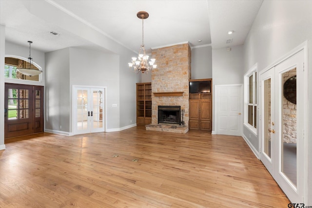 89 Eagle Cv, Mount Vernon, TX 75457 - unfurnished living room with french doors, a towering ceiling, baseboards, light wood-style flooring, and a chandelier