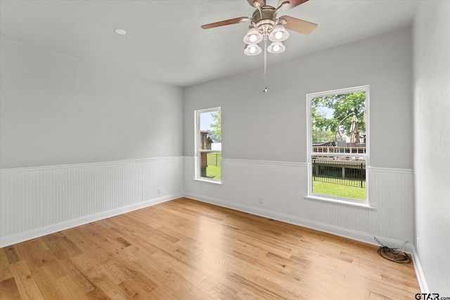 89 Eagle Cv, Mount Vernon, TX 75457 - empty room with a wainscoted wall, wood finished floors, plenty of natural light, and ceiling fan