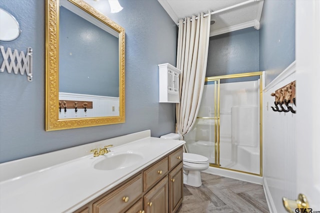 bathroom with a textured ceiling, vanity, crown molding, a shower with shower door, and toilet