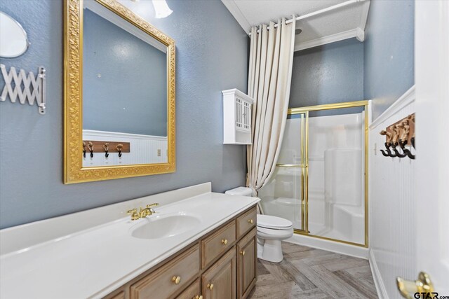 bathroom with a textured ceiling, vanity, crown molding, a shower with shower door, and toilet