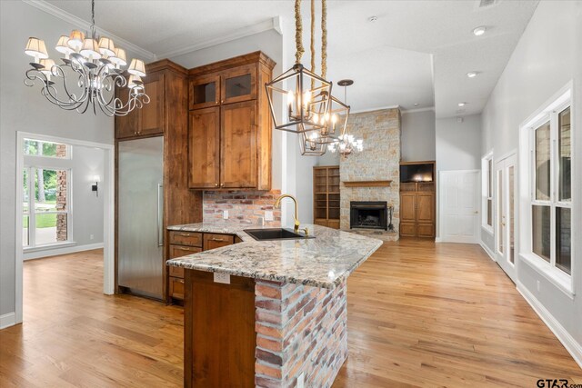 89 Eagle Cv, Mount Vernon, TX 75457 - kitchen with a sink, a chandelier, stainless steel built in fridge, brown cabinets, and light stone counters