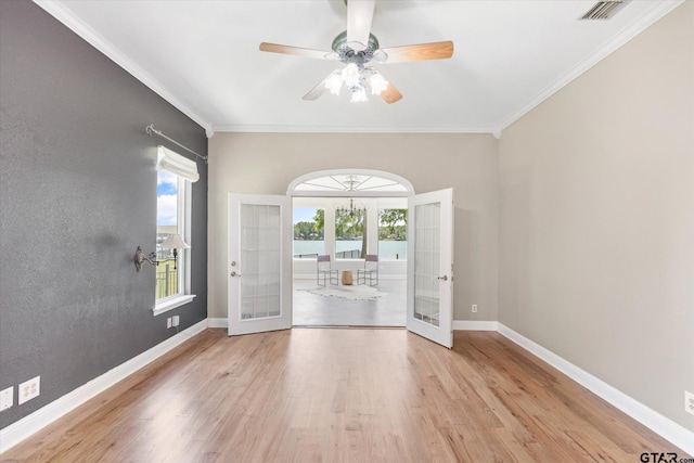 empty room featuring ornamental molding, french doors, light hardwood / wood-style flooring, and ceiling fan