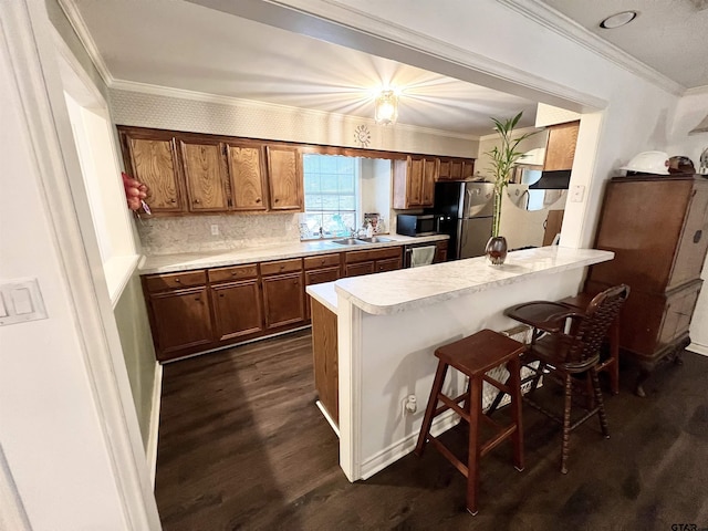 kitchen with a kitchen bar, stainless steel appliances, dark hardwood / wood-style floors, tasteful backsplash, and sink