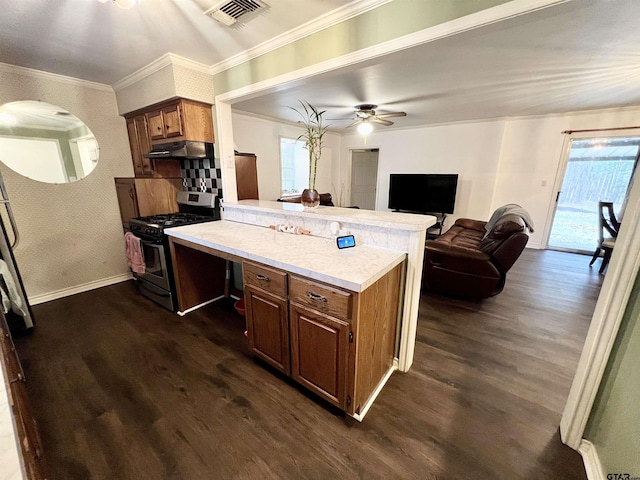 kitchen featuring ceiling fan, dark hardwood / wood-style floors, kitchen peninsula, and gas stove