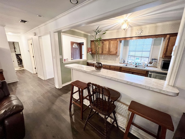 kitchen with a kitchen breakfast bar, stainless steel dishwasher, kitchen peninsula, and sink