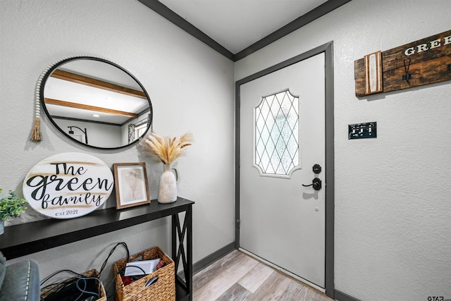 entryway with light wood-type flooring and ornamental molding