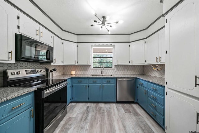 kitchen with sink, appliances with stainless steel finishes, blue cabinetry, light hardwood / wood-style flooring, and decorative backsplash