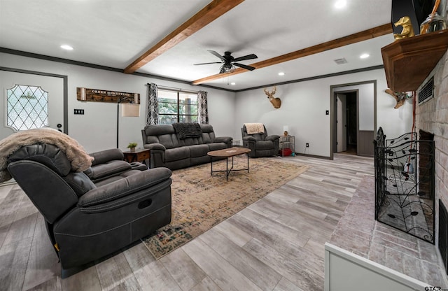 living room with a fireplace, light wood-type flooring, ceiling fan, and beam ceiling