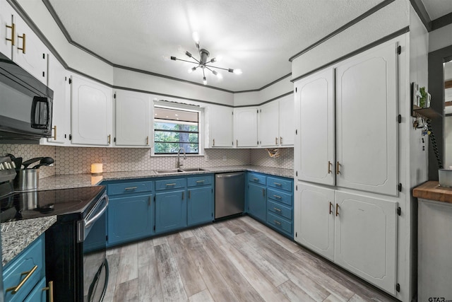 kitchen with stainless steel appliances, light wood-type flooring, a textured ceiling, sink, and blue cabinets