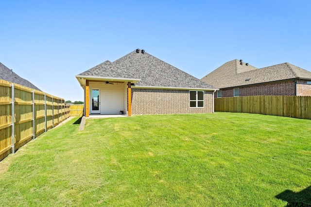 back of property featuring ceiling fan, a lawn, and a patio