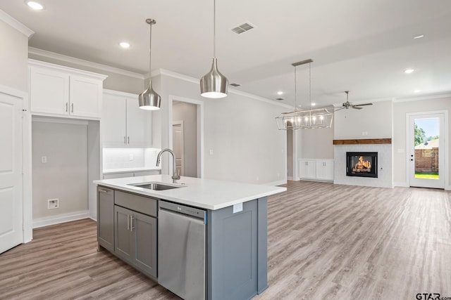 kitchen featuring pendant lighting, white cabinets, sink, a kitchen island with sink, and stainless steel dishwasher