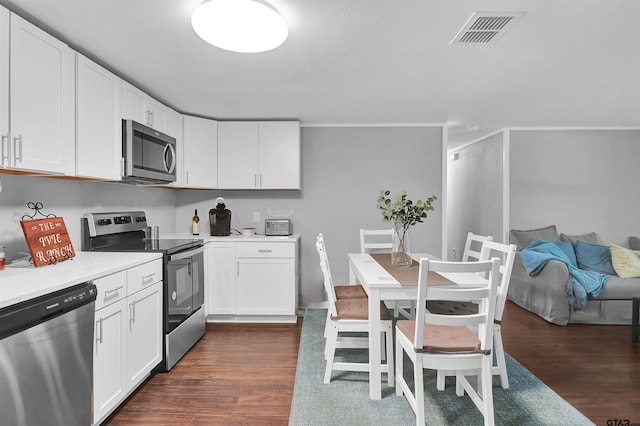 kitchen featuring dark wood-style floors, visible vents, appliances with stainless steel finishes, and white cabinetry