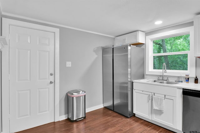 kitchen with white cabinets, a sink, stainless steel appliances, light countertops, and dark wood-style flooring