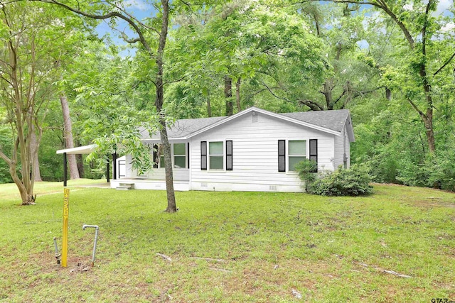 view of front of property featuring a front lawn, crawl space, a shingled roof, and an attached carport