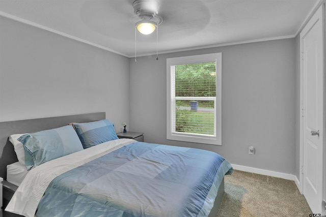 carpeted bedroom with baseboards, a ceiling fan, and crown molding