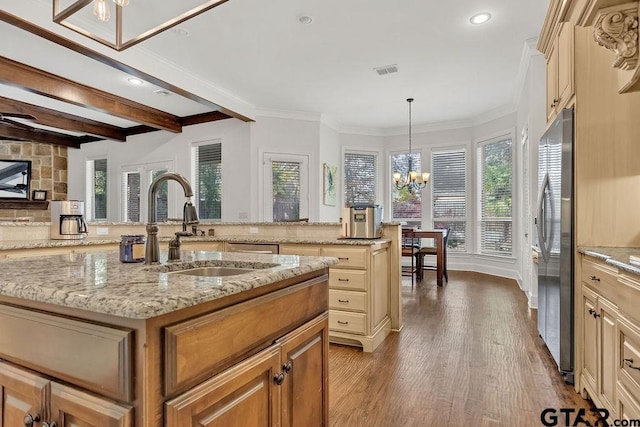 kitchen with hanging light fixtures, an inviting chandelier, stainless steel fridge, hardwood / wood-style floors, and a kitchen island with sink