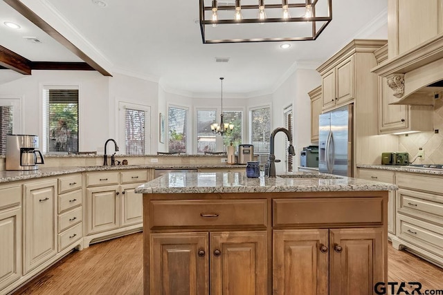 kitchen with a kitchen island with sink, an inviting chandelier, light hardwood / wood-style flooring, decorative light fixtures, and stainless steel appliances