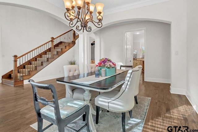 dining room with dark hardwood / wood-style floors, crown molding, and a chandelier